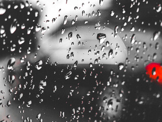  Raindrops on glass with blurred car in the background – monochrome shot.