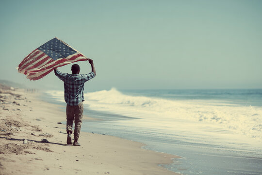 African Young American Man Waving American Flag on Beach