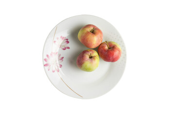 Three apples on floral porcelain plate, top view
