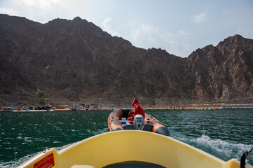 Rescue boat assisting visitors on the water at Hatta Kayak, surrounded by rocky mountains and emerald lake in Hatta