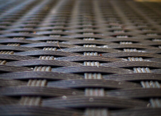 Macro shot of woven furniture with dark and light fibers. Structure is the main focus.