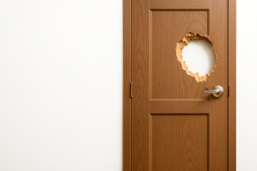 A wooden door with a round hole, a light wall. Space for text.