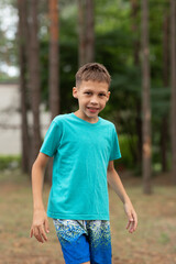 a boy child on a walk, wearing a turquoise T-shirt, standing sideways