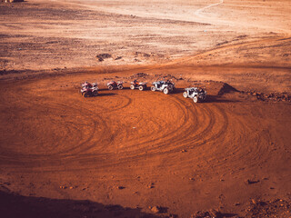Five buggies leave circular tracks in the vast desert – team spirit in solitude.
