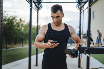 young man use mobile phone at outdoor open gym