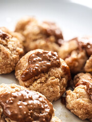 Fresh oat cookies with chocolate glaze on a plate, soft texture and sweet indulgence.