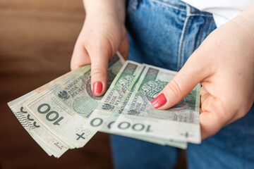 woman holds in her hands banknotes in zloty for payment, saving concept
