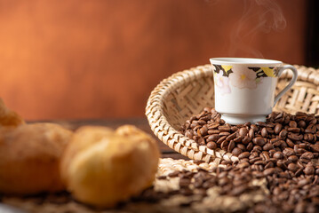Cheese bread and coffee, delicious Brazilian cheese bread and a beautiful cup of coffee on a rustic table and coffee beans, abstract background, selective focus.