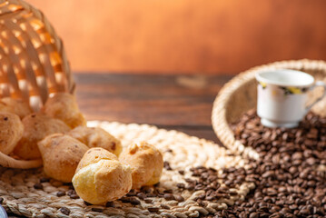 Cheese bread and coffee, delicious Brazilian cheese bread and a beautiful cup of coffee on a rustic table and coffee beans, abstract background, selective focus.