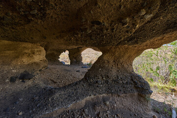 Inside volcanic cave with multiple openings