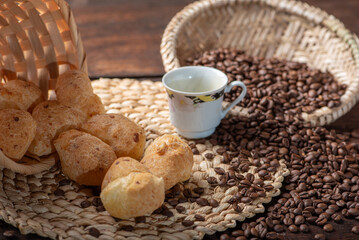Cheese bread and coffee, delicious Brazilian cheese bread and a beautiful cup of coffee on a rustic table and coffee beans, abstract background, selective focus.