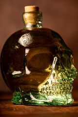 Cachaça bottle, details of a Brazilian cachaça bottle in the shape of a skull, low key photo, selective focus.