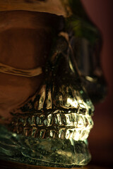 Cachaça bottle, details of a Brazilian cachaça bottle in the shape of a skull, low key photo, selective focus.