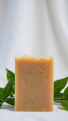 Artisan Soap Bar with Orange Peel and Green Leaves on White Background