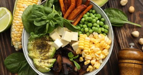 Healthy vegetarian food. Delicious Buddha bowl and ingredients on wooden table, flat lay