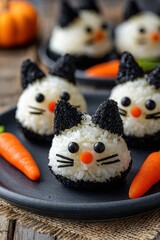 Halloween Cat Rice Balls with Seaweed Whiskers and Carrot Noses on Black Plate