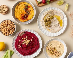  Different types of hummus in bowls and plates. Beetroot, pumpkin, chickpea and bean hummus. 