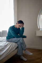 Depressed woman with headache delaying tasks following separation sit alone in bed. Broken...