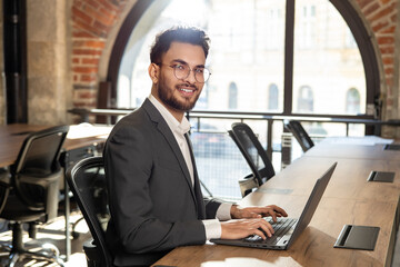 Handsome young manager working in the office and looking confident