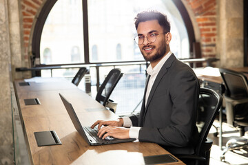 Handsome young manager working in the office and looking confident