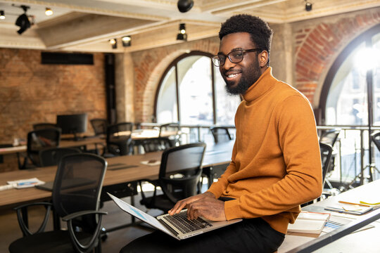 African american young man with laptop working in the office