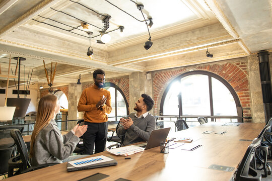 Coworkers discussing project details and looking interested