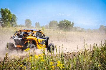 Outdoor activities UTV buggy moves on dusty road. 4x4, extreme, adrenalin.