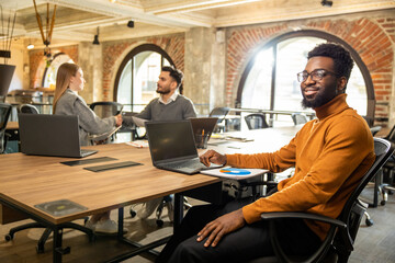 Group of young people in the office discussing project details and looking involved