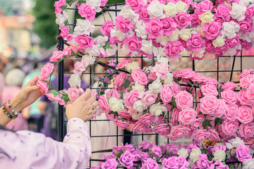 Hands of woman choosing wreath of roses. Handmade rose wreaths with customer hands selecting....