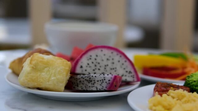 breakfast in an expensive hotel omelette fruits Dragon Fruit breadfruit on white plates on the table