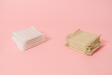 Sanitary napkins packed on pink background. Menstruation cycle, feminine hygiene and protection....