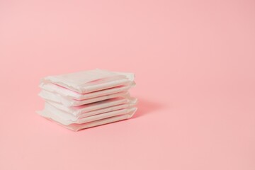 Sanitary pads packed on pink background. Concept of menstruation, ovulation, reproduction, pain and personal hygiene. Flat layout