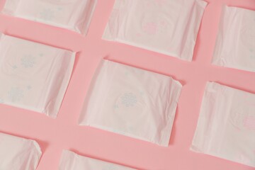 Flat layout of sanitary napkins on pink background. Menstruation cycle, feminine hygiene and...