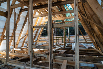 Construction of a wooden house frame with wooden roof underway