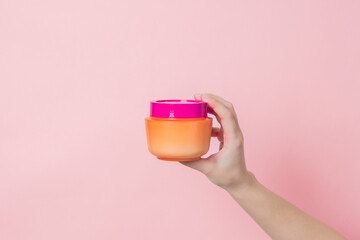 Hand holds cosmetic bottle for hair mask, balm or body lotion. Daily beauty product. Product cosmetic advertising