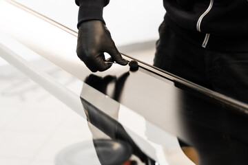 Applying primer on car frame before windshield installation. Applying black primer on car frame...