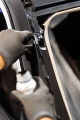 Applying primer on car frame before windshield installation. Applying black primer on car frame...
