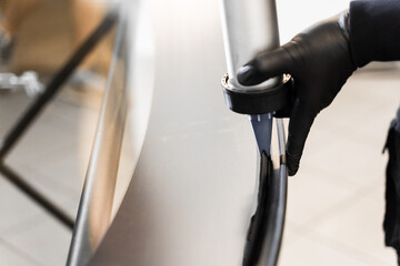 Urethane caulking gun applies flexible adhesive, forming a watertight seal at car windshield replacement. Applying adhesive to a car windshield using a caulking gun.