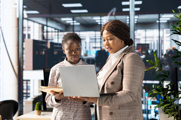 Professional team analyzing archived data on a modern device, collaborating on enterprise solutions...