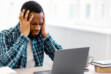 Stressed Black Businessman Having Headache Sitting At Laptop Having Problem At Workplace In Modern...