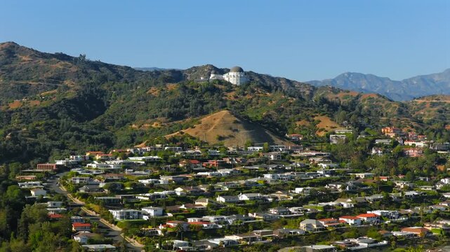 Los Angeles 07.07.2024. Enchanting beauty of Griffith Observatory with suburban living with picturesque homes among rolling hills and a clear blue skyideal for inspiring potential buyers 