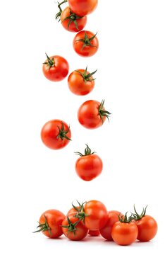 Multiple ripe red tomatoes falling in sequence against clean white background. Illustration features full depth of field, capturing fruit in crisp detail. Vibrant imagery perfect for food blogs,