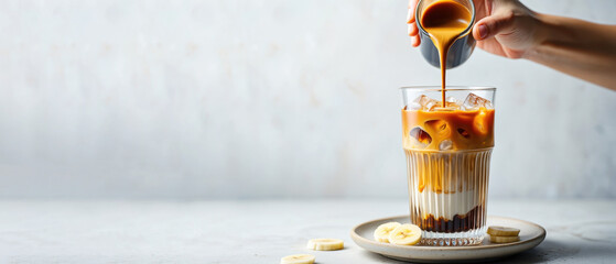 Banana bread latte, iced banana coffee banner, espresso with banana, layered iced latte, cold summer drink, creamy coffee, banana milk latte, trendy beverage, dessert coffee, copy space