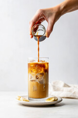 Banana bread latte, iced banana coffee, banana espresso, summer drink, cold banana latte, creamy iced beverage, trendy coffee, flavored latte, hand pouring espresso, dessert coffee