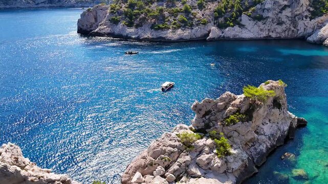 Vid&eacute;o d'une vue plongeante sur un bateau touristique au milieu de la mer et des calanques en France