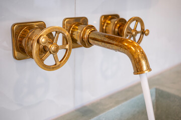 Brass Water Faucet Over a Green Concrete Sink in a Luxury Hotel