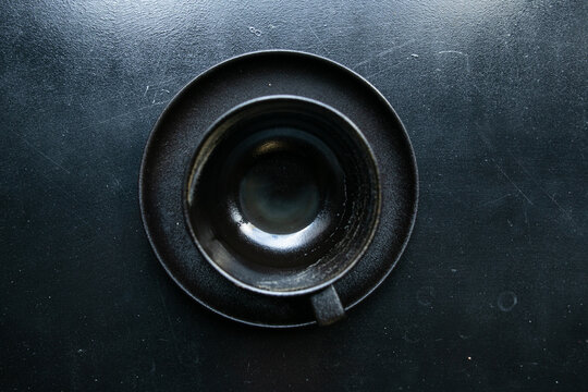 black empty cup stands on saucer top view