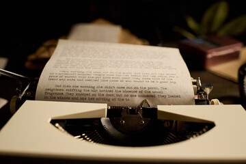 Closeup showing vintage typewriter with typed manuscript page emerging, focusing on typed text and...
