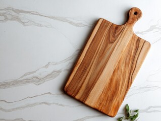 Wooden cutting board with rounded handle on light marble surface