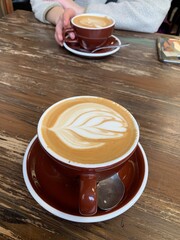 Barista art coffee couple date on wooden bench, hand holding mug